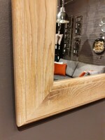 Minimalistyczne lustro w drewnianej ramie.